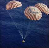3 parachutes guiding spacecraft to ocean